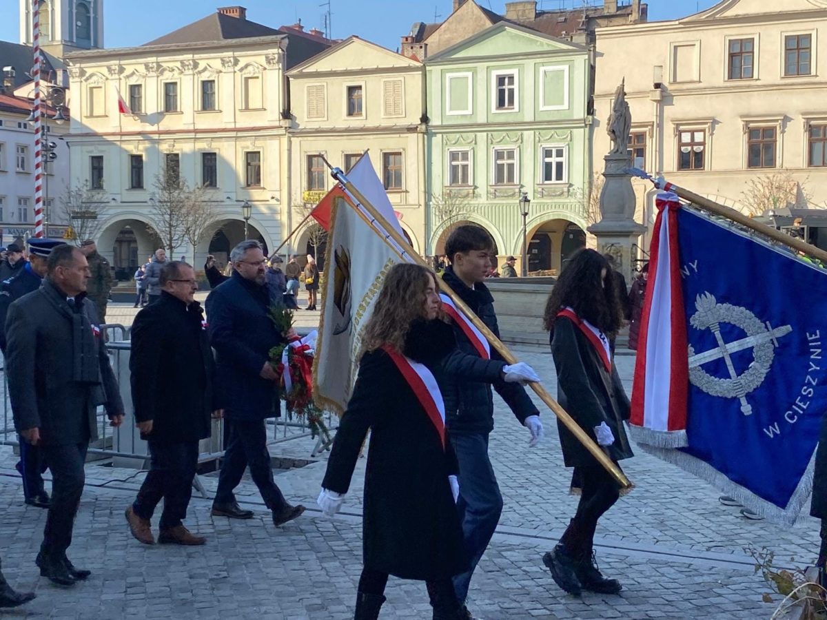 uczniowie idący ze sztandarem