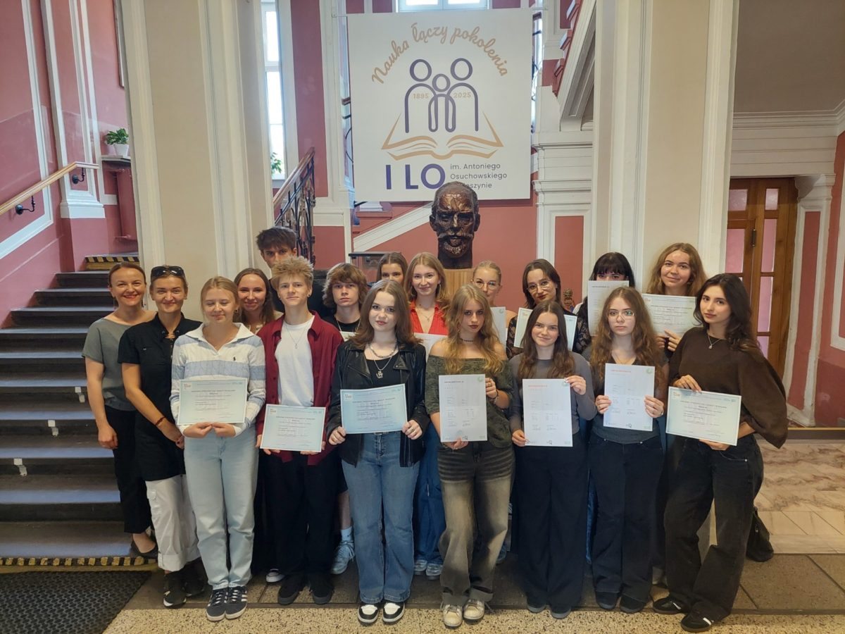 uczniowie stoją z dyplomami