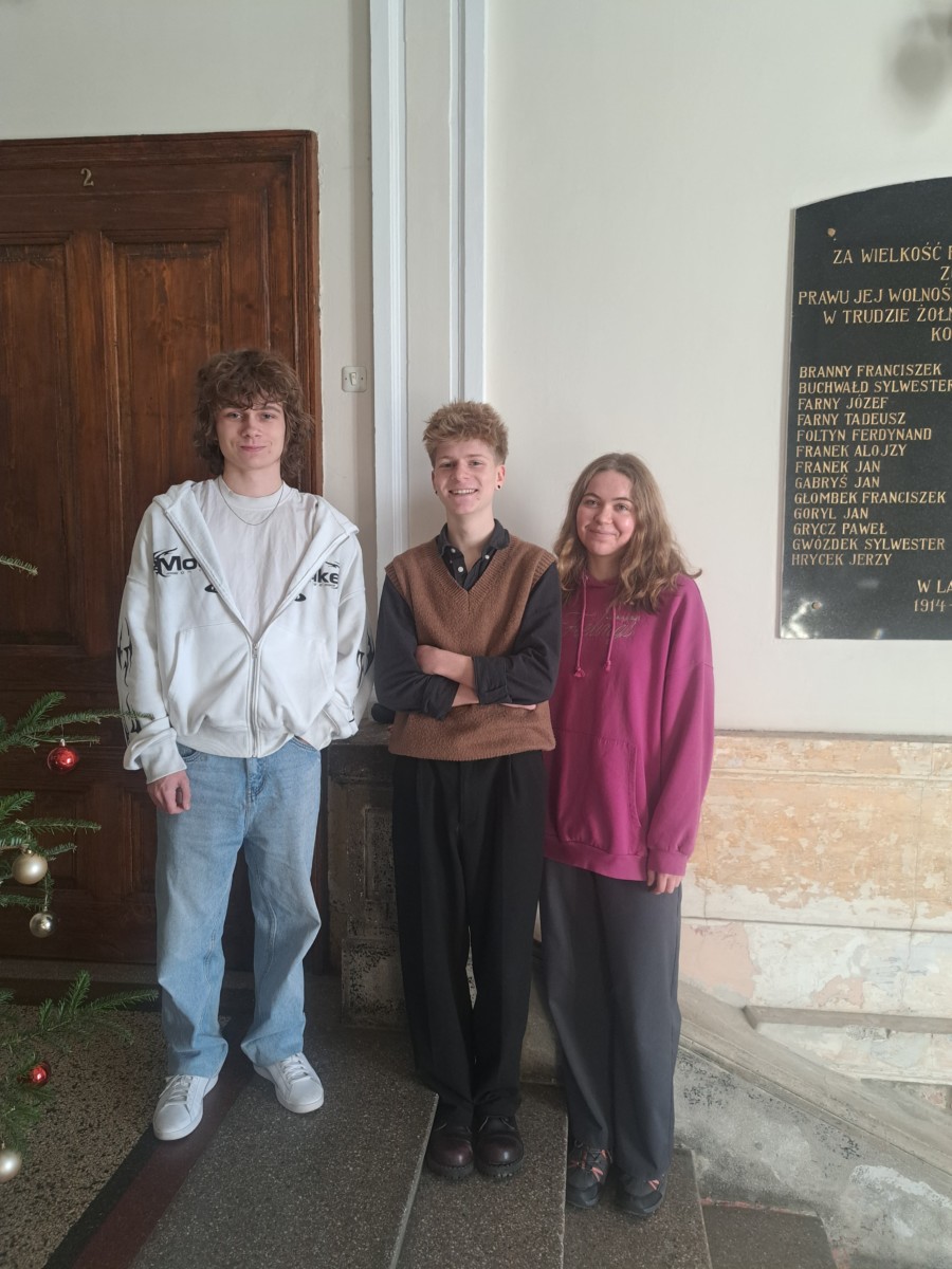 trzy osoby stoją przy ścianie