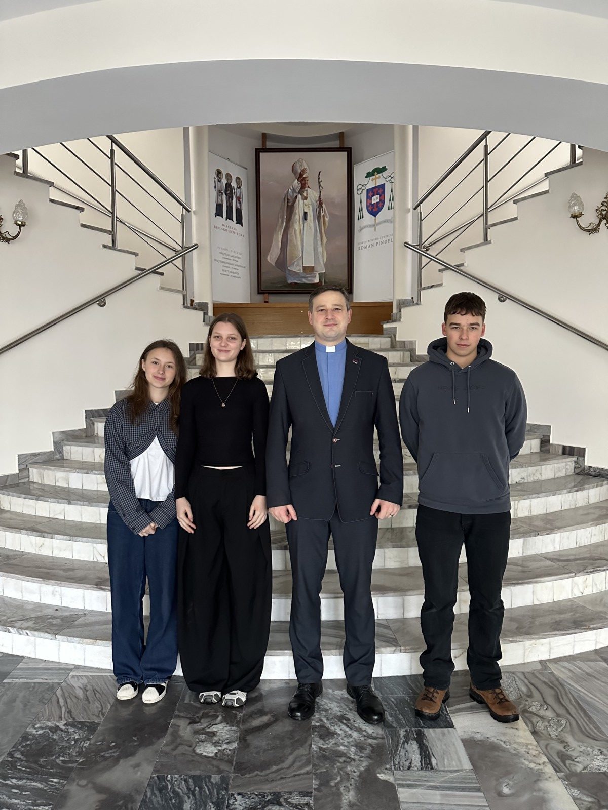 trzy osoby stoją na schodach