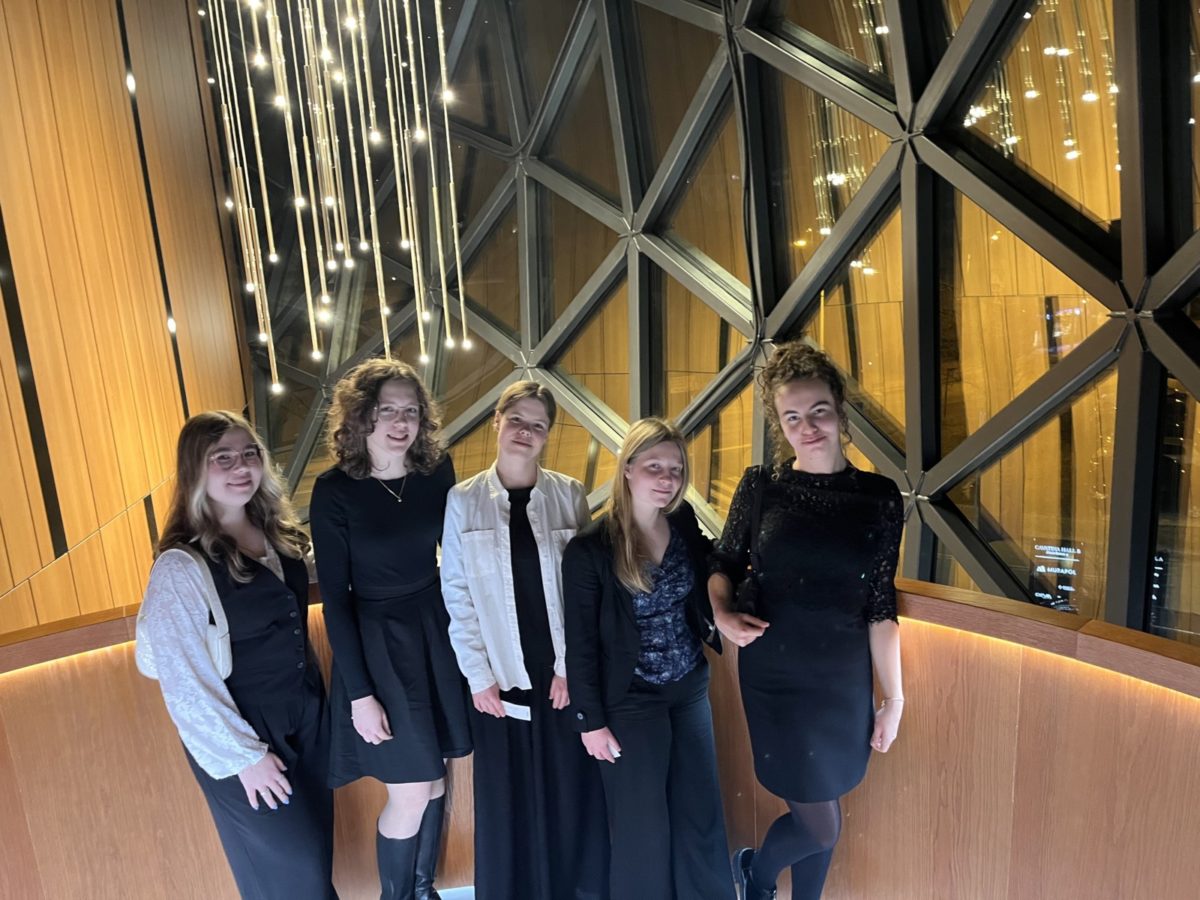 dziewczyny stoją na tle ozdobnej ściany